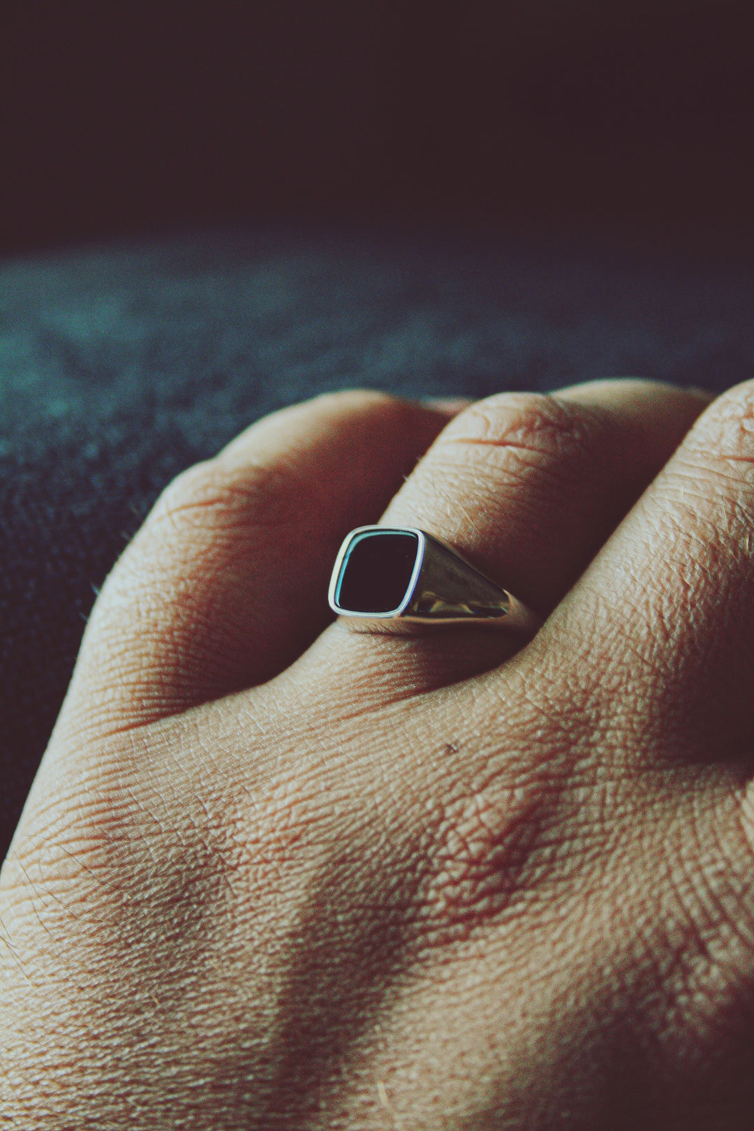 Männerhand trägt einen 925 Silber Siegelring mit schwarzen Achat Edelstein in 8mm Breite von Deinschmuck by TL