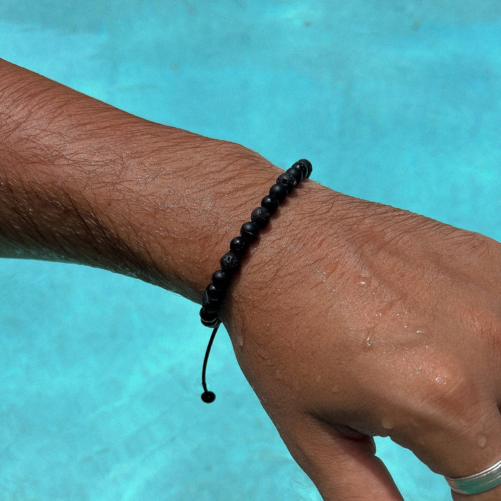 Maennliches_Model_traegt_Schwarzes_Perlenarmband_aus_6mm_Onyx_und_Lava_Edelstein_Perlen_mit_Makramee_Verschluss_von_DeinSchmuck_by_TL