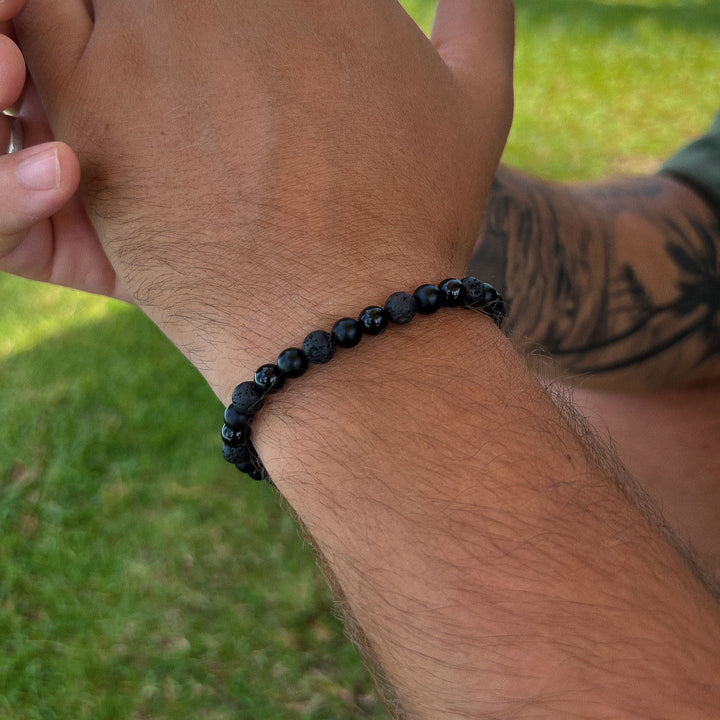 Maennliches_Model_traegt_Schwarzes_Perlenarmband_aus_6mm_Onyx_und_Lava_Edelstein_Perlen_mit_Makramee_Verschluss_von_DeinSchmuck_by_TL_2
