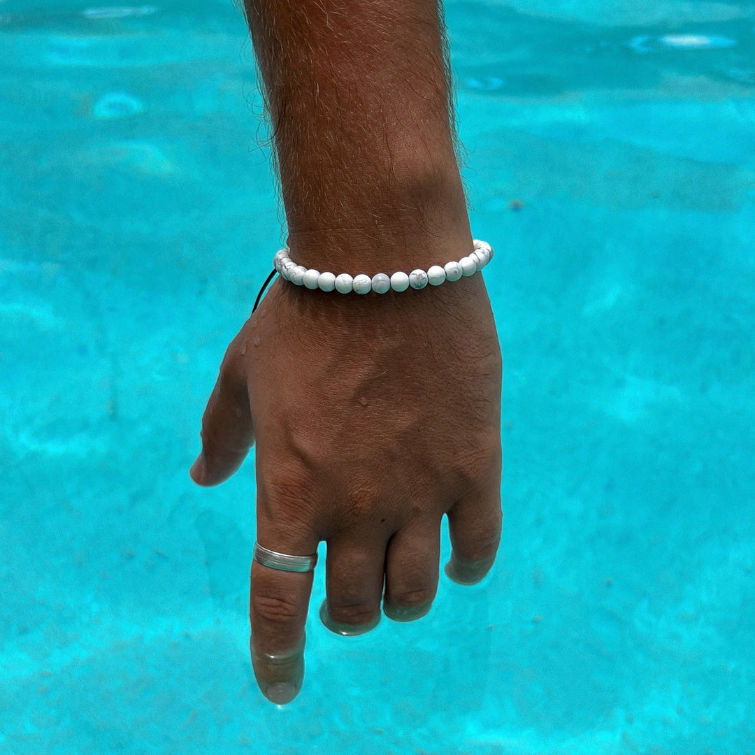 Maennliches_Model_traegt_ein_weisses_Perlenarmband_aus_glaenzenden_6mm_Howlith_Edelstein_Perlen_mit_Makramee_Verschluss_von_DeinSchmuck_by_TL_2