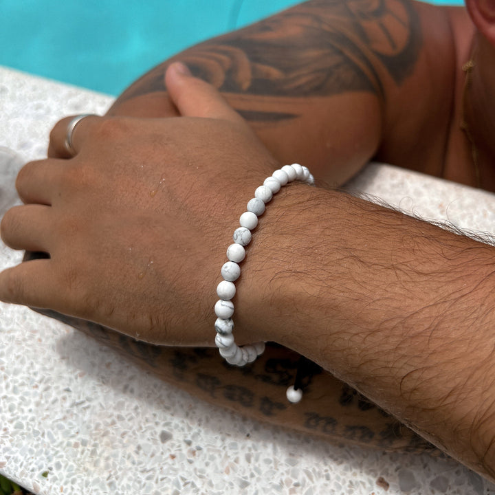 Maennliches_Model_traegt_weisses_Perlenarmband_aus_6mm_glaenzenden_Howlith_Edelstein_Perlen_mit_Makramee_Verschluss_von_DeinSchmuck_by_TL